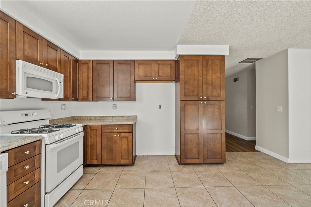 30008 Abelia Road Canyon Country, CA 91387 - Photo 11 of 32 a kitchen with stainless steel appliances granite countertop a refrigerator stove and sink