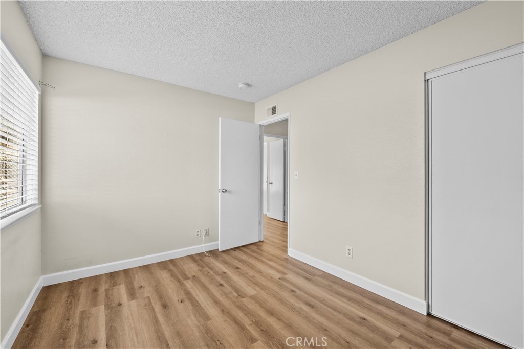 30008 Abelia Road Canyon Country, CA 91387 - Photo 19 of 32 a view of an empty room with wooden floor and a window