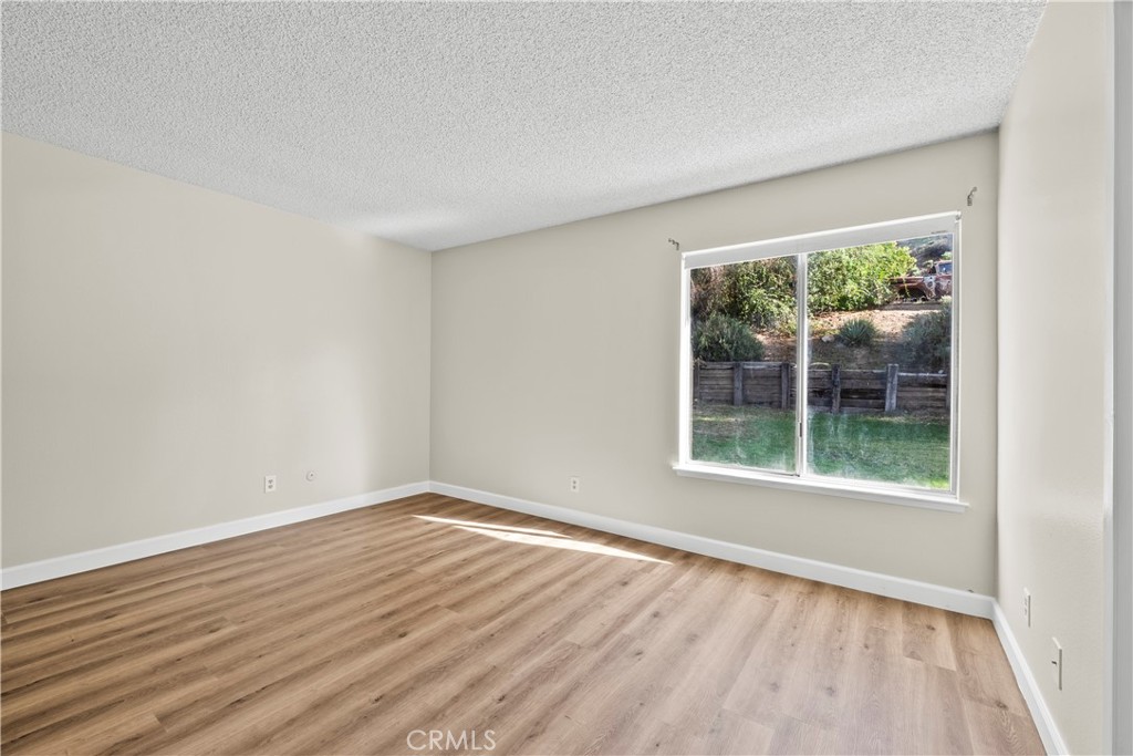 30008 Abelia Road Canyon Country, CA 91387 - Photo 21 of 32 an empty room with wooden floor and a window