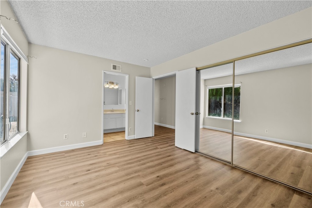 30008 Abelia Road Canyon Country, CA 91387 - Photo 22 of 32 a view of an empty room with wooden floor and a window