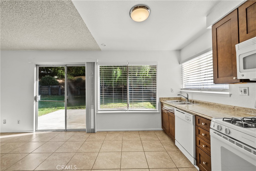 30008 Abelia Road Canyon Country, CA 91387 - Photo 10 of 32 a kitchen with a stove a sink and a granite counter tops