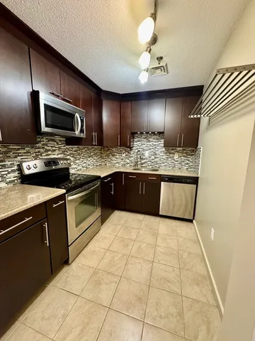 a large kitchen with cabinets and stainless steel appliances