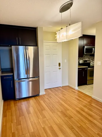 a kitchen with stainless steel appliances granite countertop a refrigerator and a stove