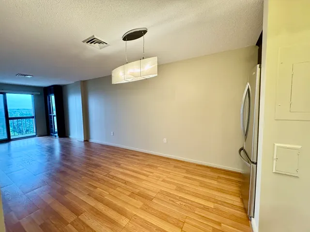 a view of an empty room with wooden floor
