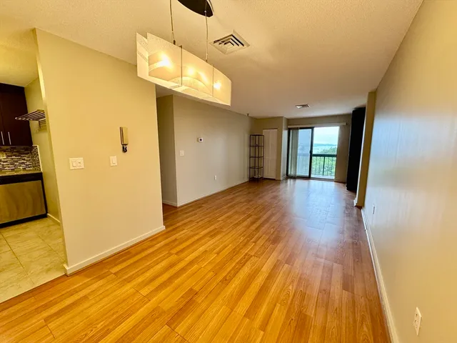 a view of a room with wooden floor and a window