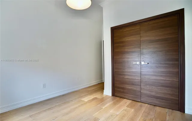 an empty room with closet and wooden floor