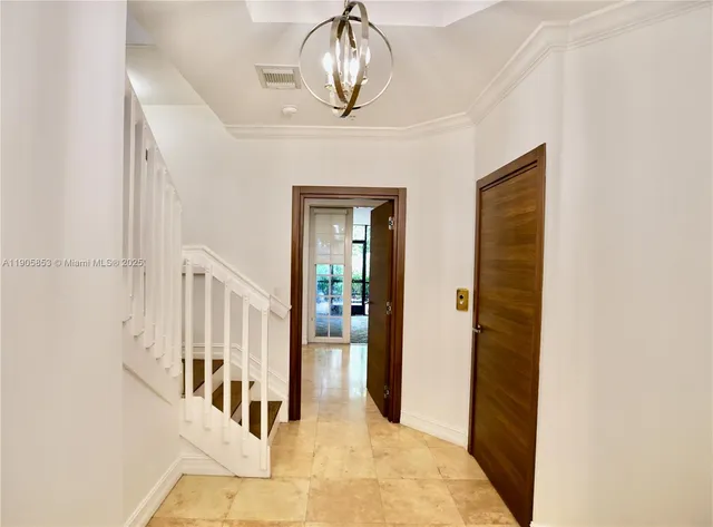 a view of a hallway with wooden floor and chandelier