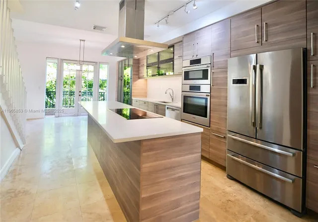 a kitchen with kitchen island a counter top space stainless steel appliances and a large window