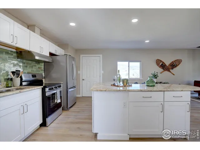 a kitchen with stainless steel appliances granite countertop a sink a stove and a refrigerator