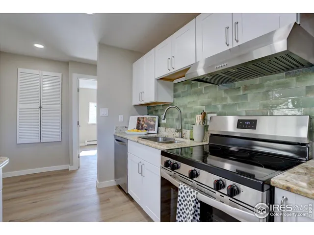 a kitchen with a stove and wooden cabinets
