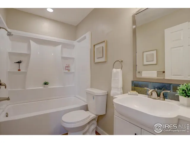 a bathroom with a granite countertop toilet sink and mirror