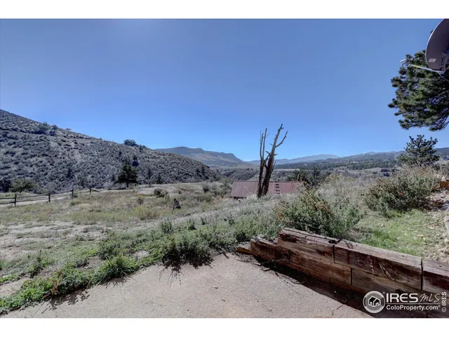a view of a dry yard with a house in the background