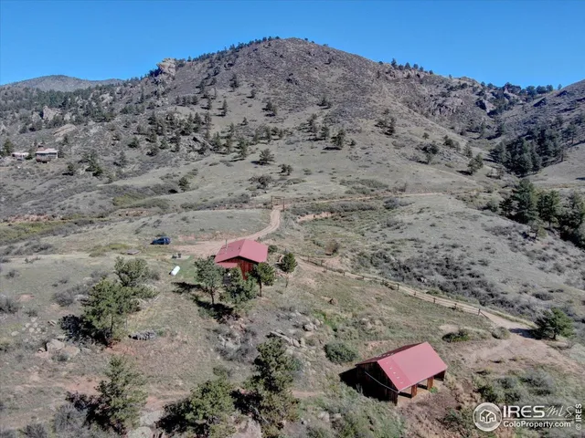 a view of a dry field with mountains in the background