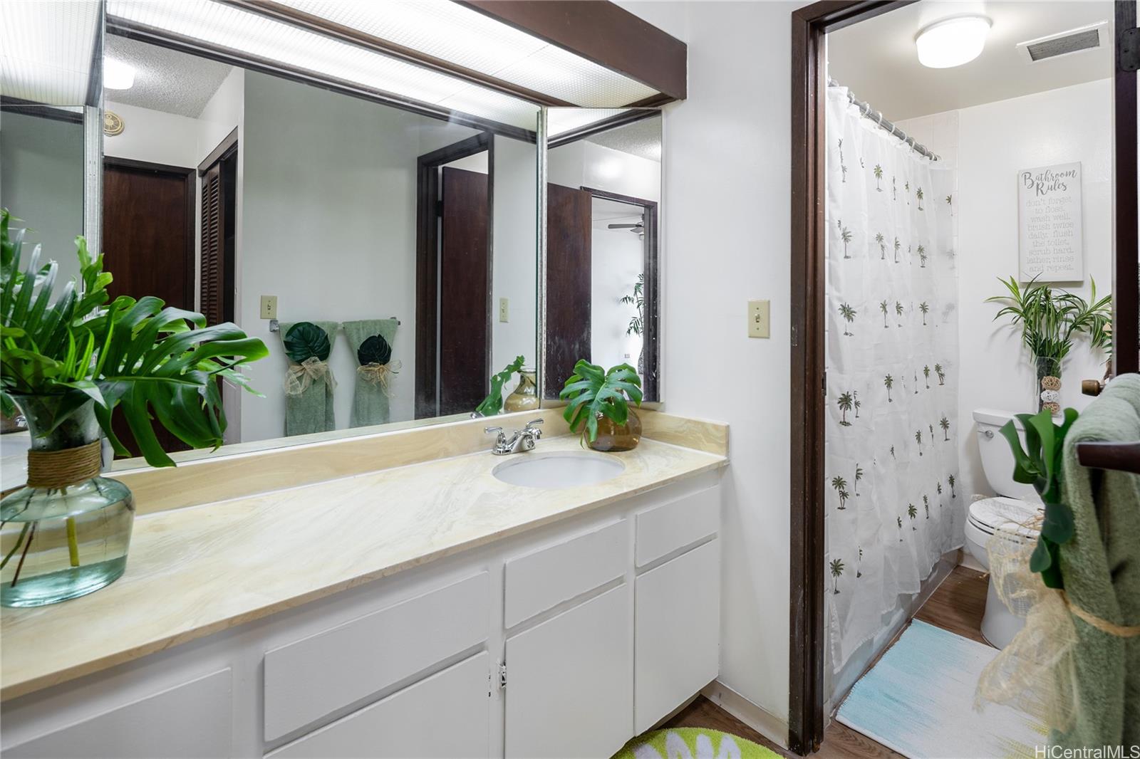 98-450 Koauka Loop, Unit 1108 Aiea, HI 96701 - Photo 11 of 22 a bathroom with a sink a mirror and a potted plant