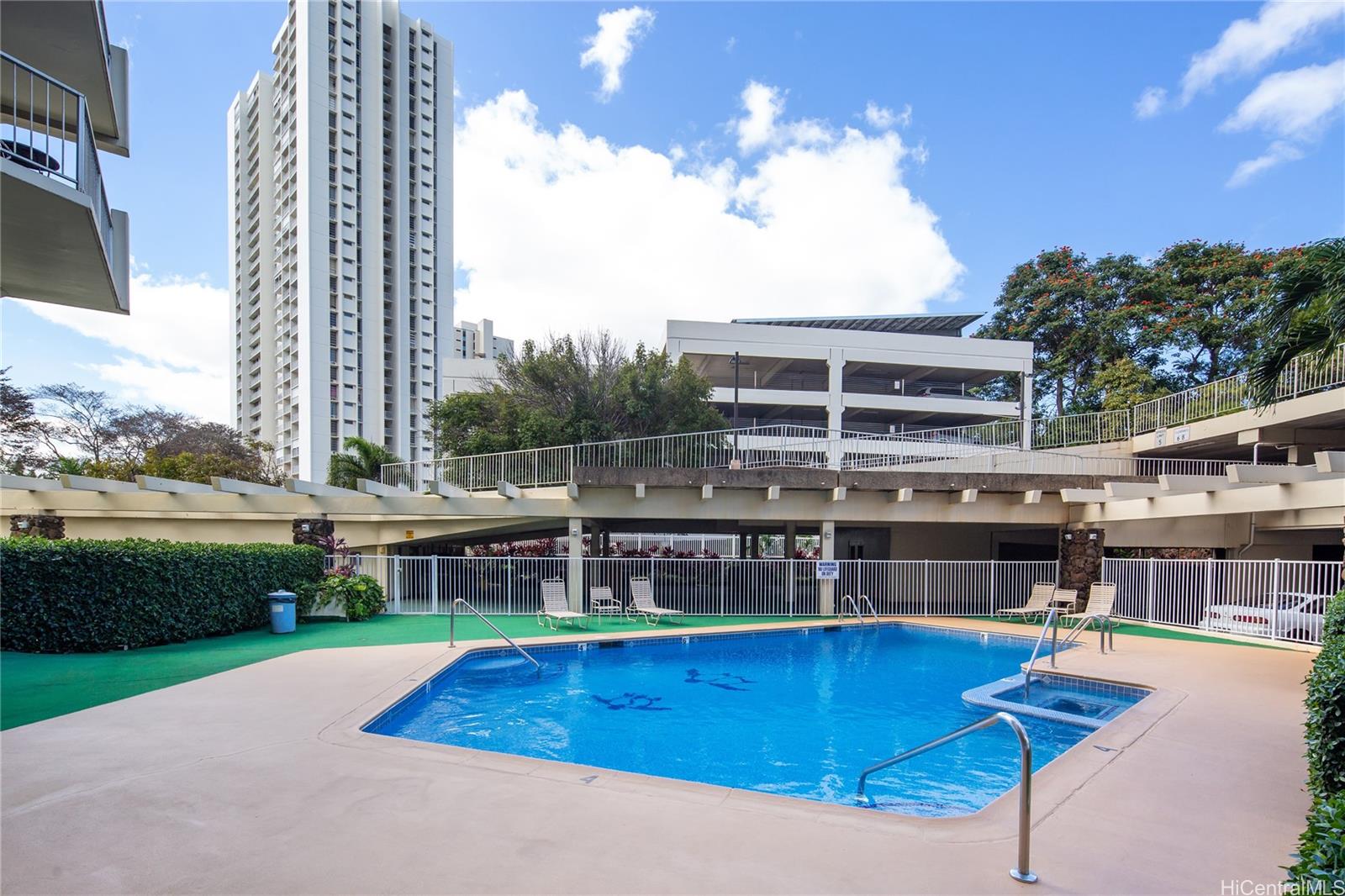 98-450 Koauka Loop, Unit 1108 Aiea, HI 96701 - Photo 13 of 22 a view of a swimming pool with a lounge chair