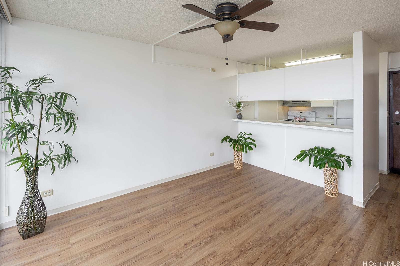 98-450 Koauka Loop, Unit 1108 Aiea, HI 96701 - Photo 3 of 22 a view of a hallway with wooden floor and plant