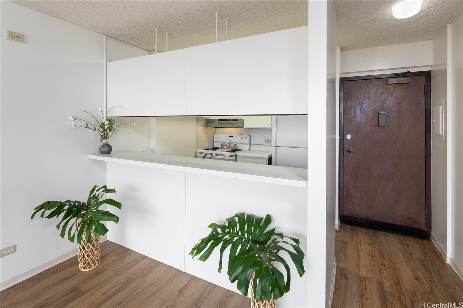 98-450 Koauka Loop, Unit 1108 Aiea, HI 96701 - Photo 5 of 22 a potted plant sitting in a kitchen next to a window