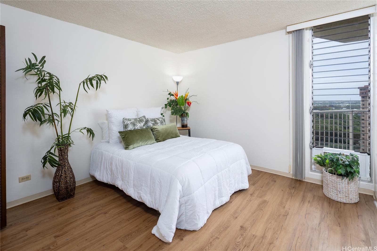 98-450 Koauka Loop, Unit 1108 Aiea, HI 96701 - Photo 8 of 22 a bed sitting in a spacious bedroom next to a window