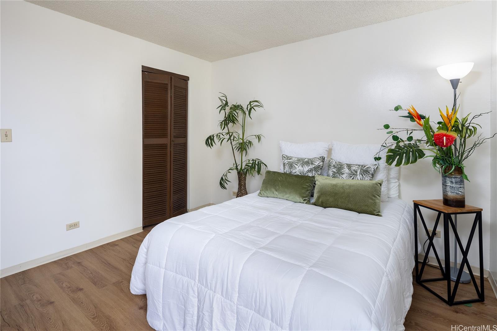 98-450 Koauka Loop, Unit 1108 Aiea, HI 96701 - Photo 9 of 22 a bedroom with a large bed and a potted plant