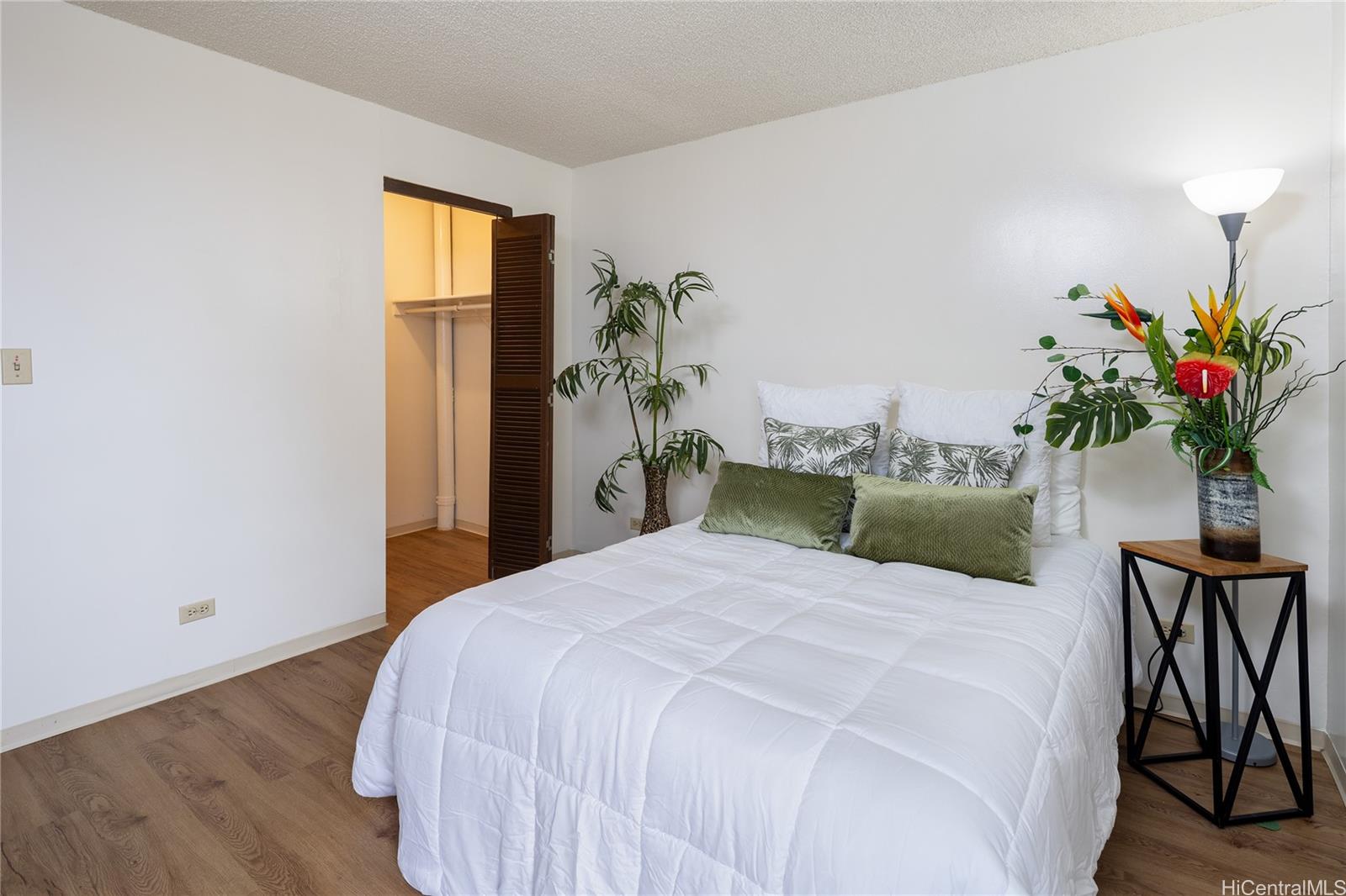 98-450 Koauka Loop, Unit 1108 Aiea, HI 96701 - Photo 10 of 22 a bedroom with a bed and a potted plant