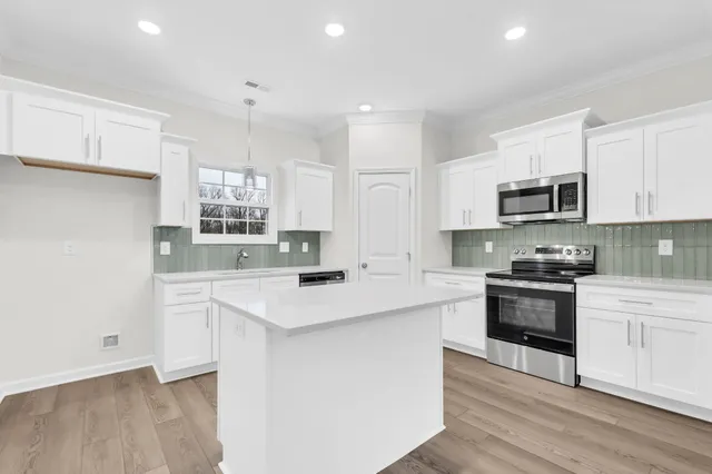 a kitchen with granite countertop white cabinets and white appliances