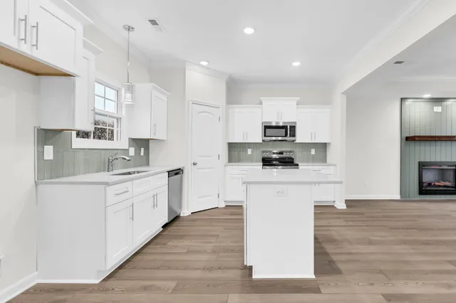 a kitchen with stainless steel appliances granite countertop a sink a window and cabinets