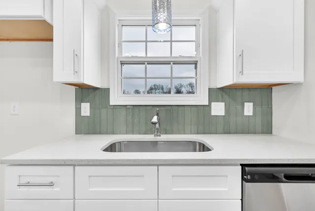 a view of a room with wooden floor chandeliers and kitchen