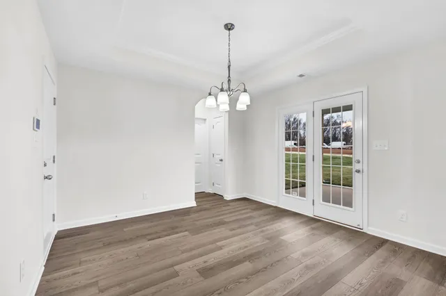 a view of a kitchen with wooden floor and a chandelier