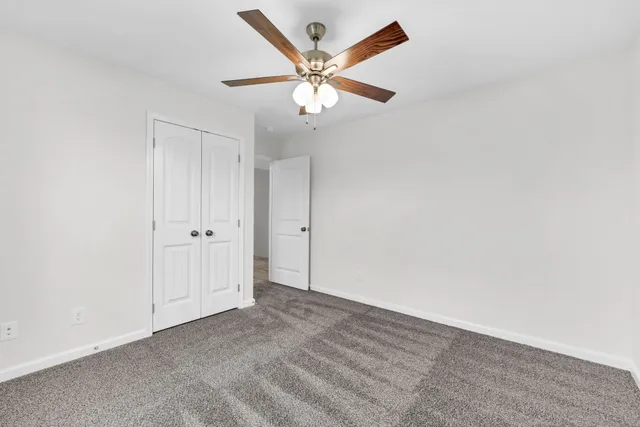 an empty room with a window and a fan
