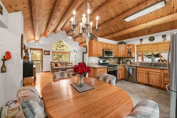 a large kitchen with a table chairs stove and cabinets