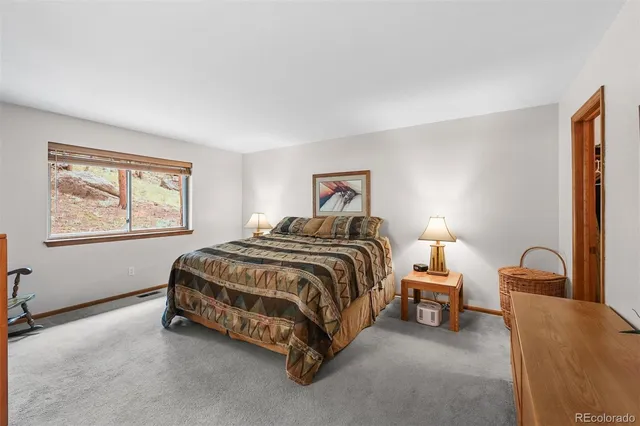 a spacious bedroom with a bed and a lamp with window