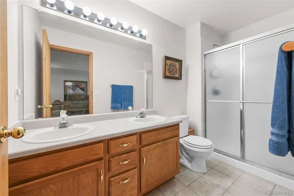 a bathroom with a double vanity sink toilet and mirror