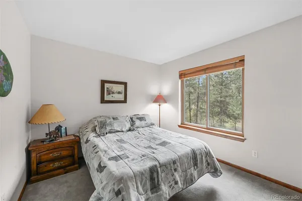 a bedroom with a bed and a lamp on dresser