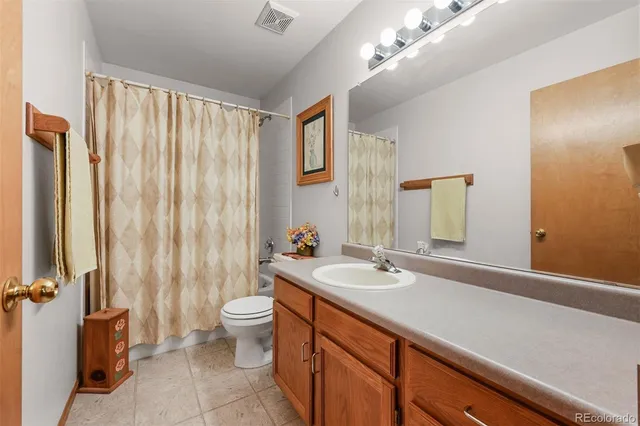 a bath room with a sink a toilet and a mirror