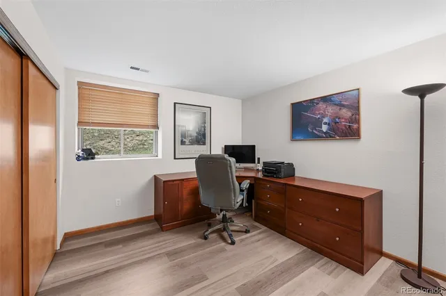 a view of a workspace with furniture and a window