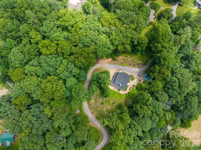 an aerial view of a house with a yard and trees