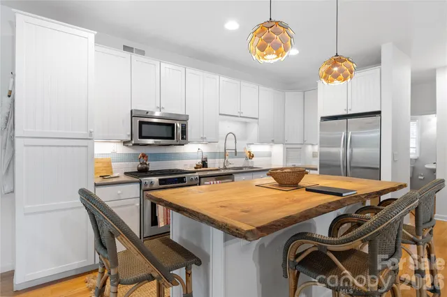 a kitchen with a sink a kitchen island and stainless steel appliances
