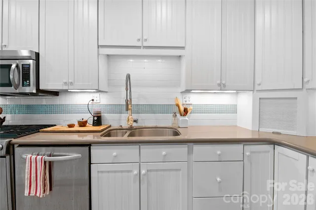 a kitchen with stainless steel appliances granite countertop a sink a stove and cabinets