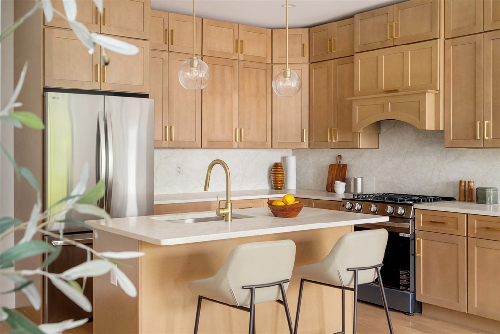 a kitchen with stainless steel appliances granite countertop a sink refrigerator and cabinets