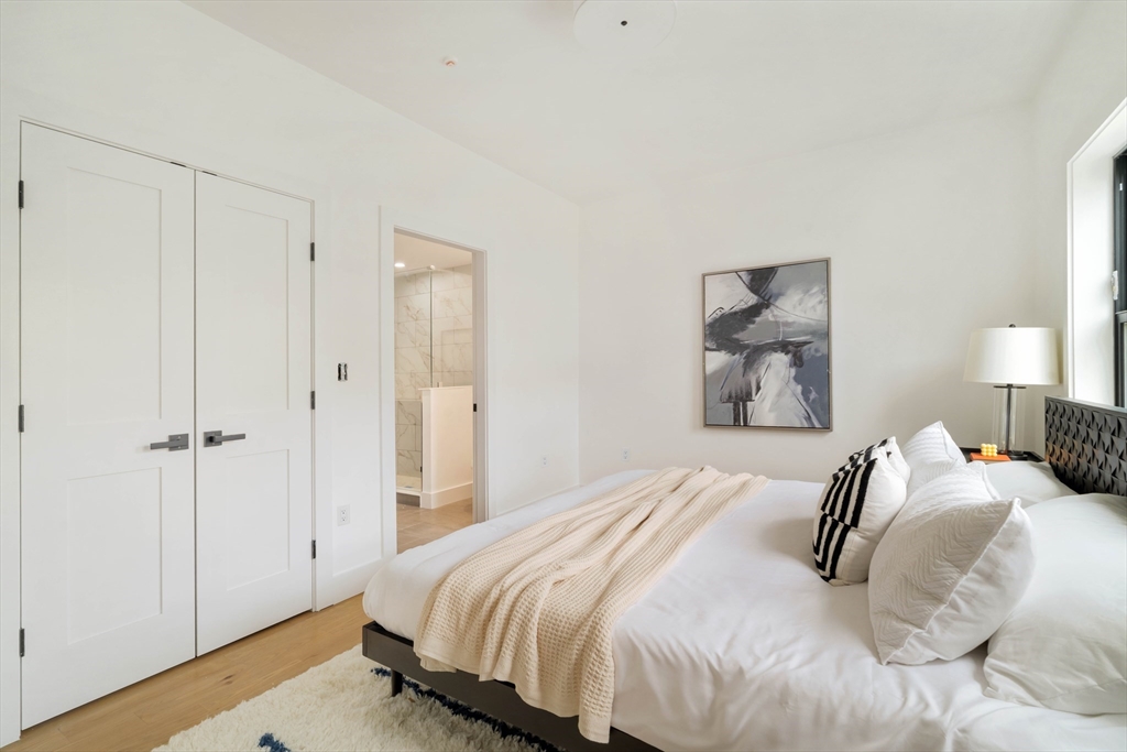 95 Addison Street, Unit PH7 Boston, MA 02128 - Photo 13 of 17 a bedroom with a bed and a painting on the wall