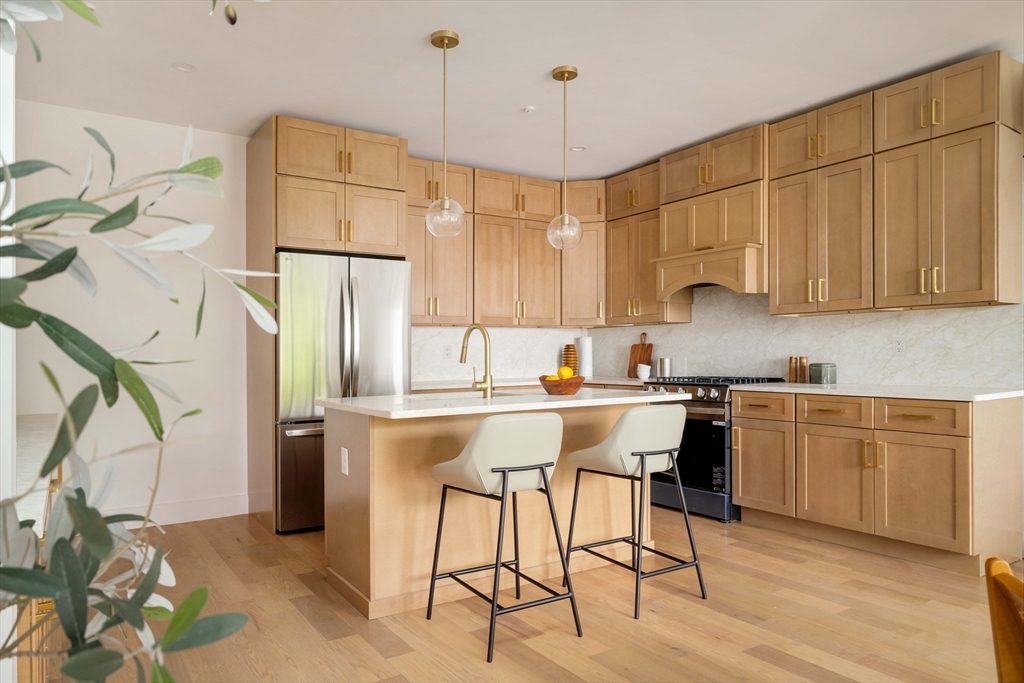 95 Addison Street, Unit PH7 Boston, MA 02128 - Photo 2 of 17 a kitchen with a table chairs refrigerator and cabinets