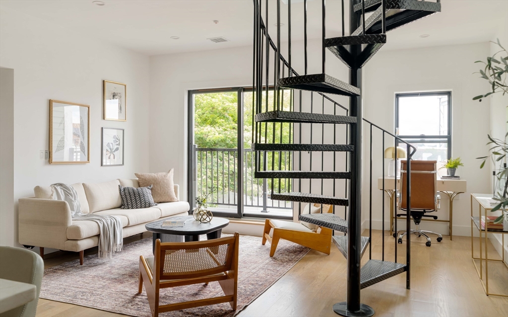 95 Addison Street, Unit PH7 Boston, MA 02128 - Photo 4 of 17 a living room with furniture a rug and a floor to ceiling window