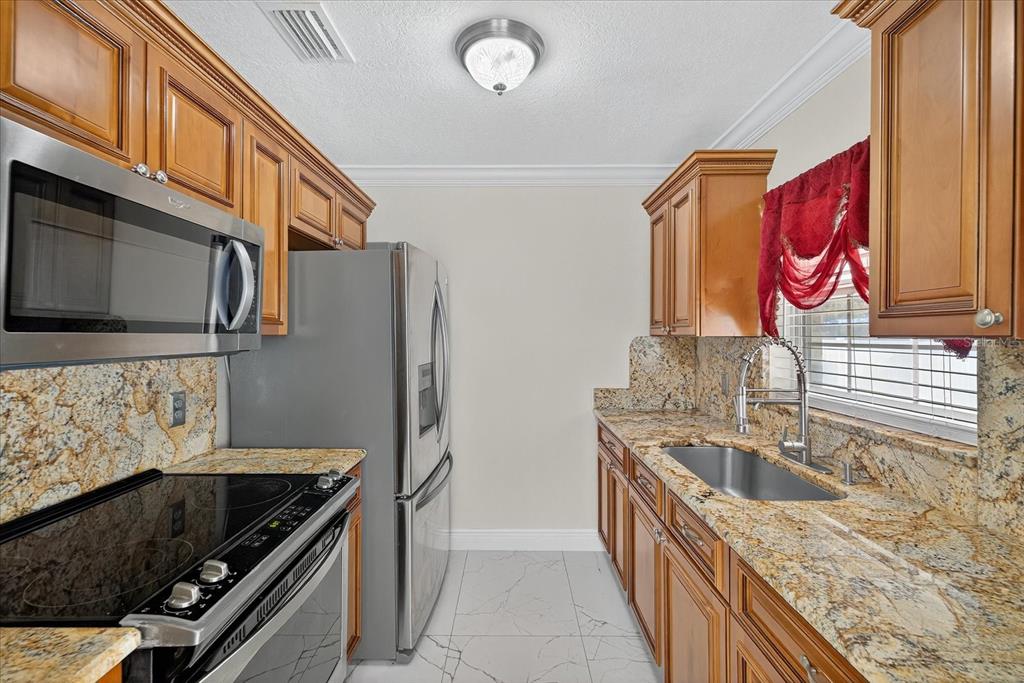 2015 Balfour Circle Tampa, FL 33619 - Photo 19 of 42 a kitchen with stainless steel appliances granite countertop a sink and a microwave