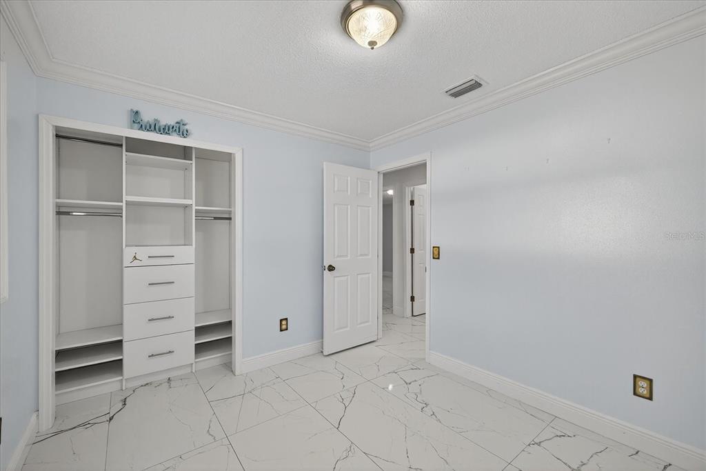 2015 Balfour Circle Tampa, FL 33619 - Photo 27 of 42 a view of walk in closet with empty racks