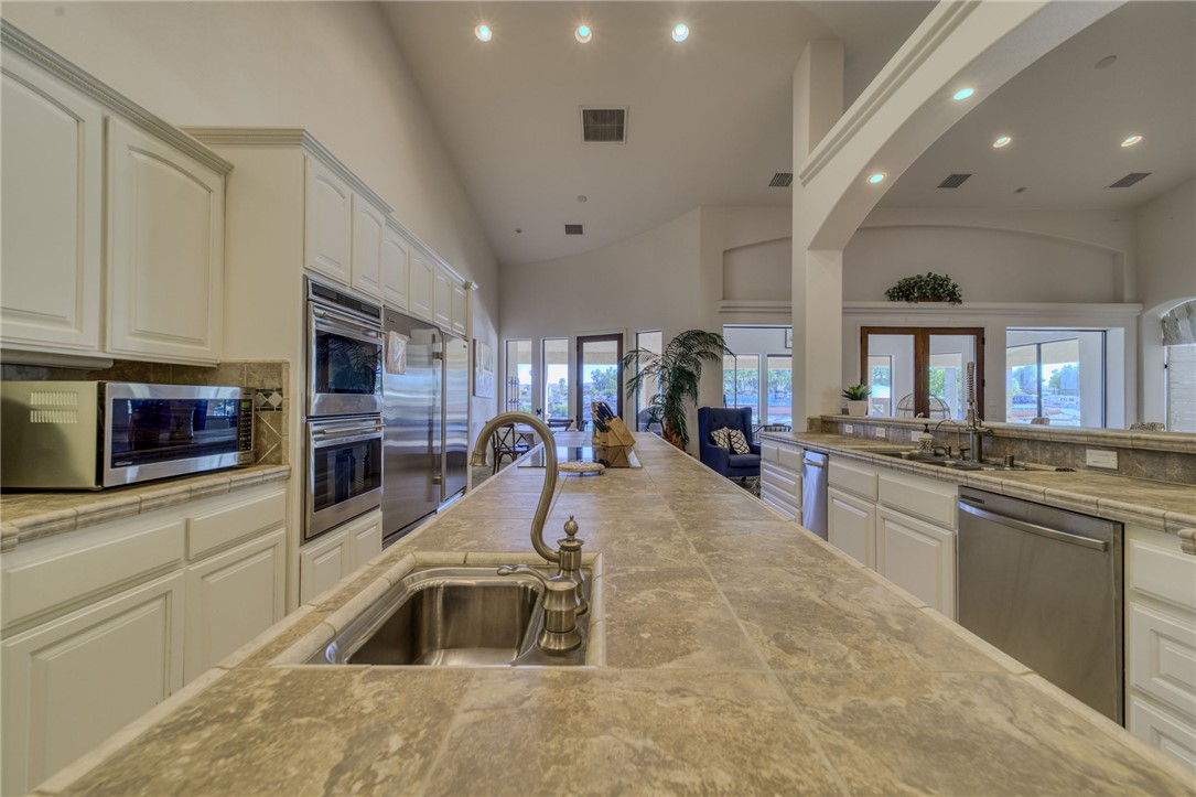 10023 Dike Road Mohave Valley, AZ 86440 - Photo 19 of 100 a kitchen with stainless steel appliances granite countertop a sink a stove and cabinets