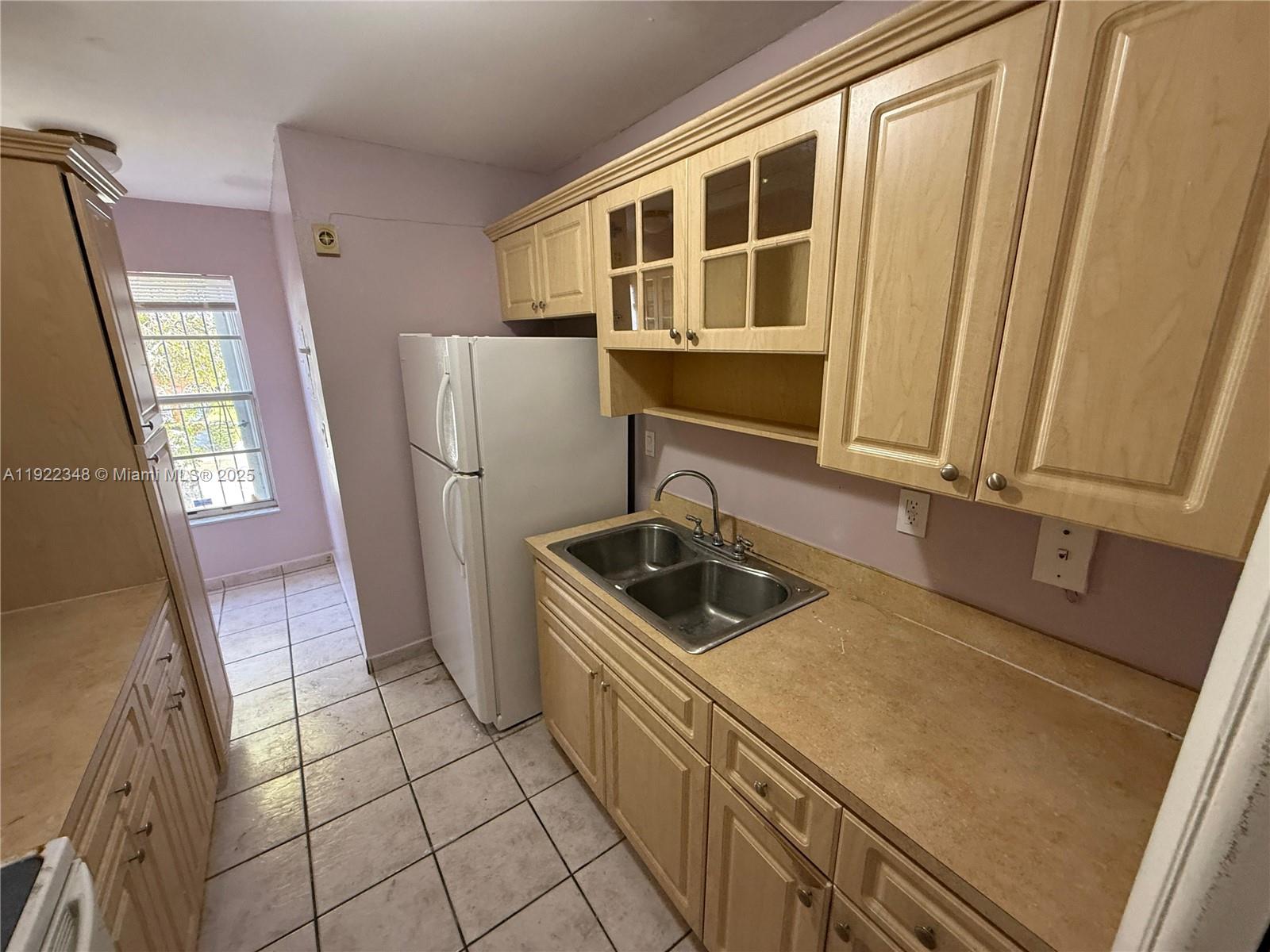 7355 West 4th Avenue, Unit 214 Hialeah, FL 33014 - Photo 1 of 15 a kitchen with a sink a refrigerator and a stove