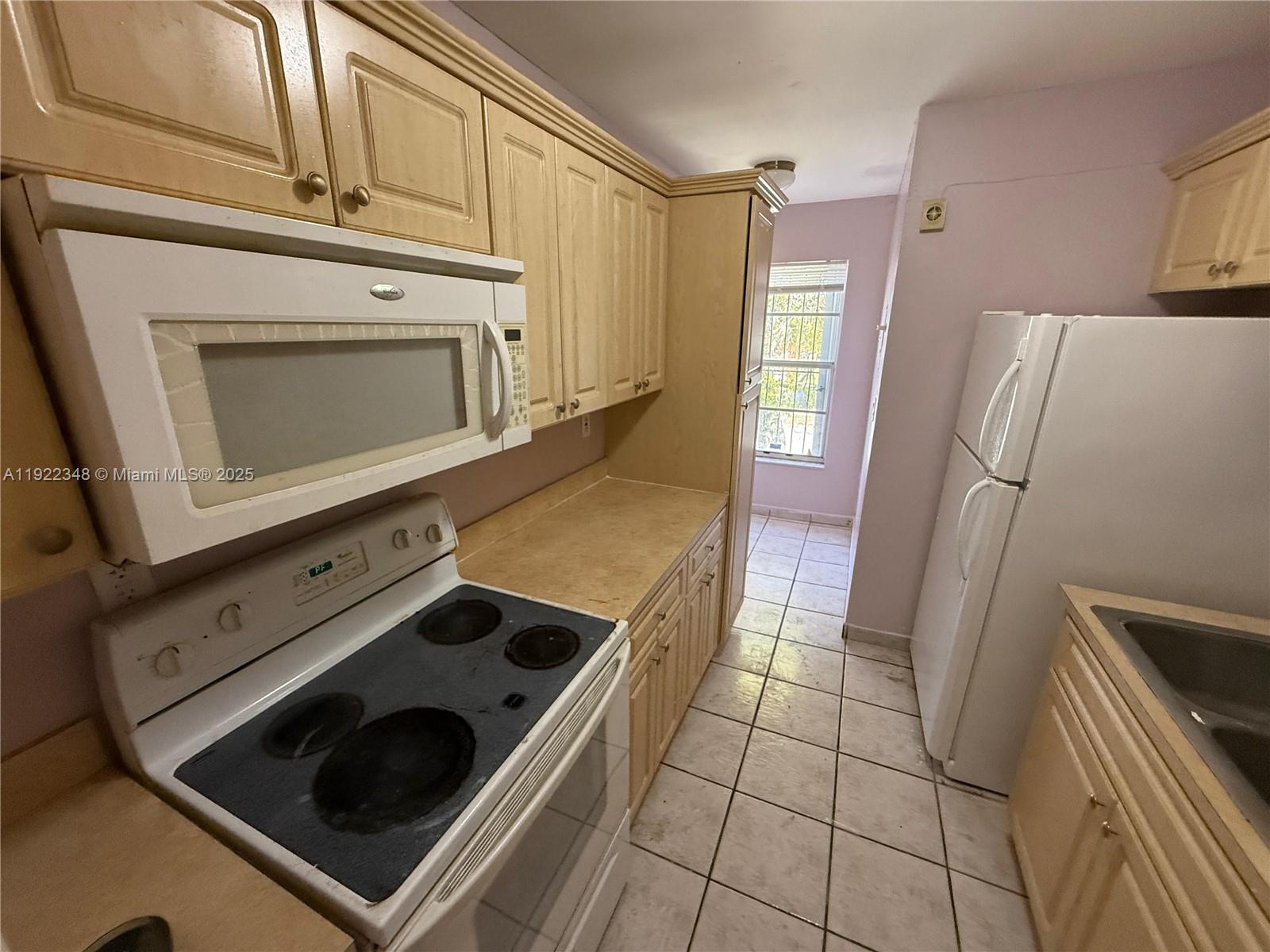 7355 West 4th Avenue, Unit 214 Hialeah, FL 33014 - Photo 2 of 15 a kitchen with a stove and a microwave