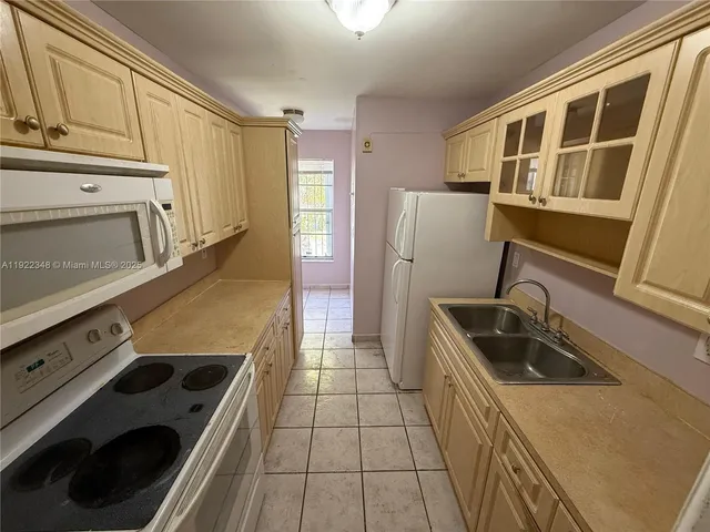 a kitchen with a stove a refrigerator and a sink