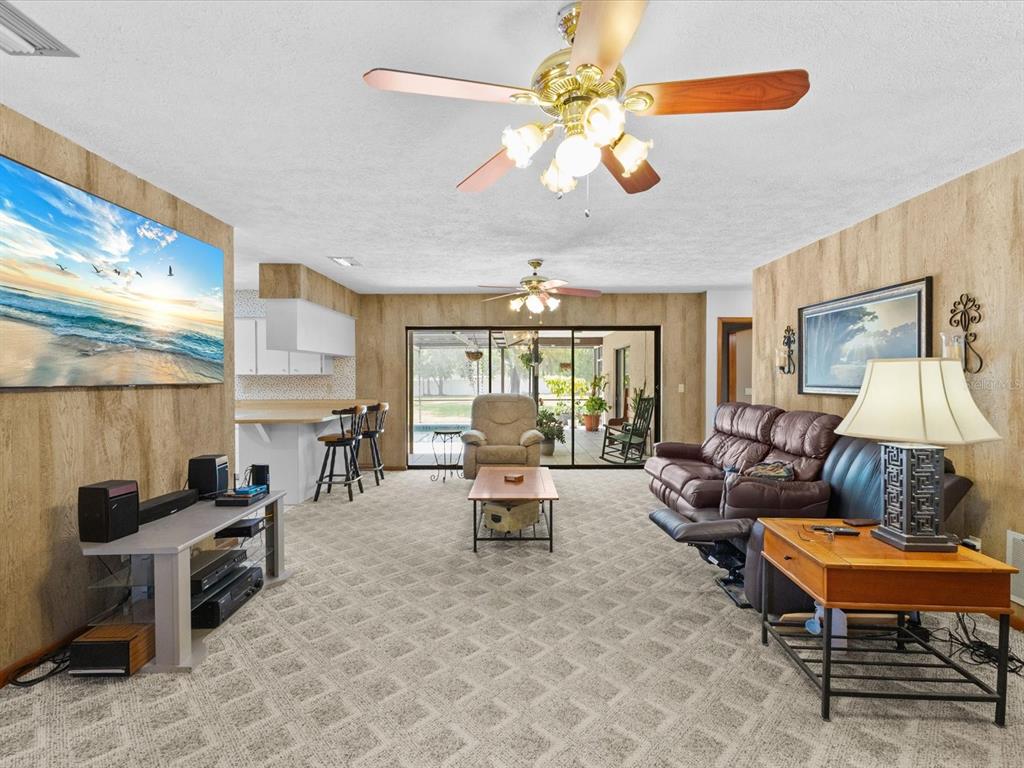 10700 Luscombe Court New Port Richey, FL 34654 - Photo 14 of 64 a living room with furniture a lamp and a large window
