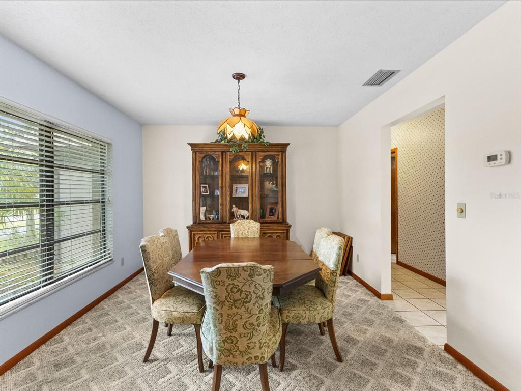 10700 Luscombe Court New Port Richey, FL 34654 - Photo 18 of 64 a view of a dining room with furniture and a chandelier